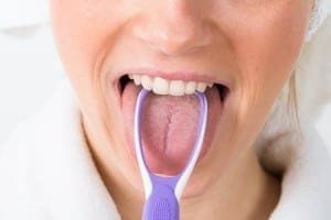 40246109 - Close-Up Of A Woman Cleaning Her Tongue