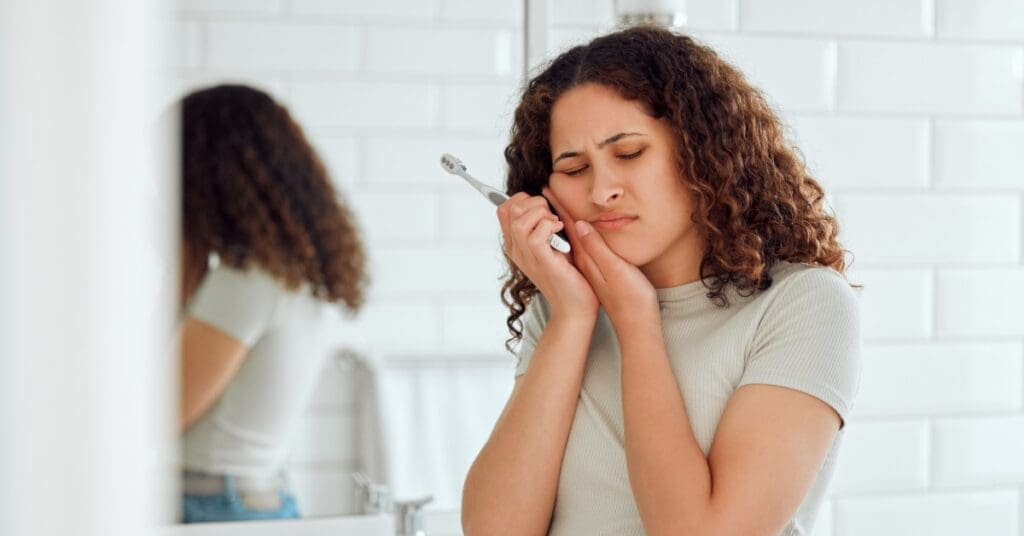 Woman Brushing Her Teeth With Pain, Concept Of Tooth Sensitivity