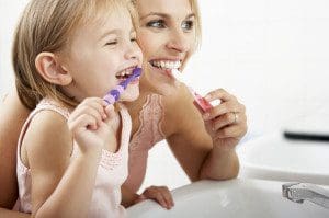 42254340 - Mother And Daughter Brushing Teeth Together