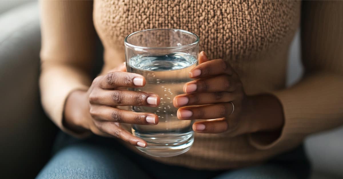 Woman Holding Glass Of Water In Front Of Stomach, Concept Of Crohn'S &Amp; Ulcerative Colitis: