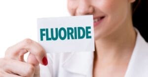 woman holding a fluoride sign