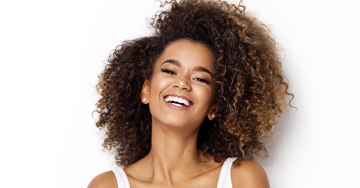 African American woman smiling, concept of Achieve Radiant Pearly Whites: 7 Tips for a Beautiful Smile